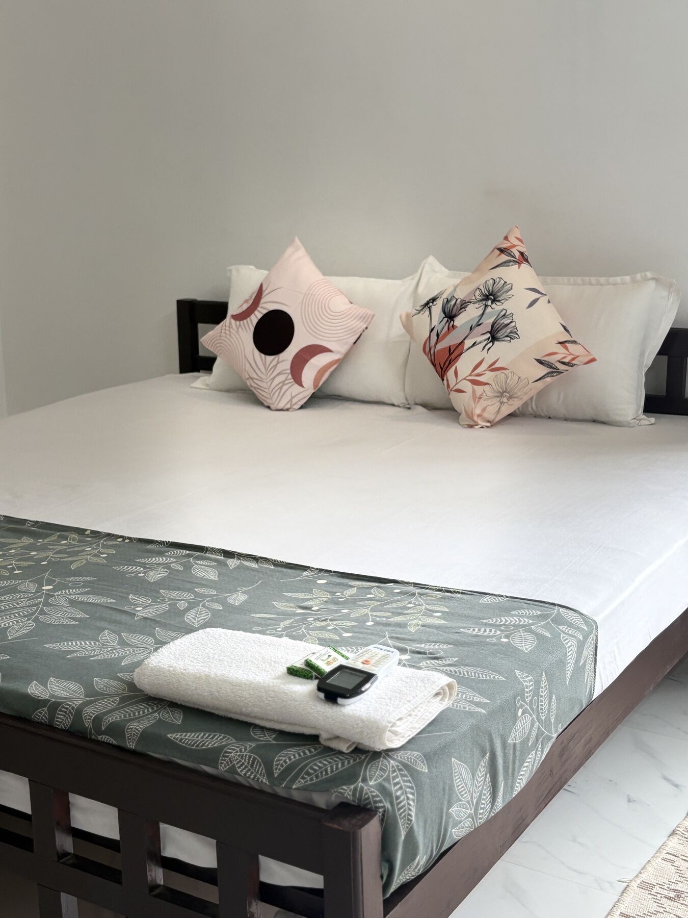 Fresh white linen, cushions and folded towels on the bed in a ZENWAYS room